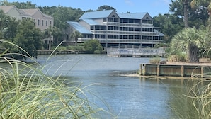 A waterfront hotel with a large building featuring multiple windows and a covered deck area.