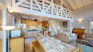 Un loft amplio con cocina, comedor y una escalera que lleva a un nivel superior.