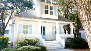 A two-story house with a porch, white siding, and blue shutters. - Beautiful Cottage on Hilton Head Island, White (Hilton Head Island)