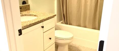 A bathroom with a toilet, sink, and bathtub.