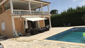 A two-story building with a balcony, a swimming pool, and outdoor seating. - Location Villa (Fréjus)