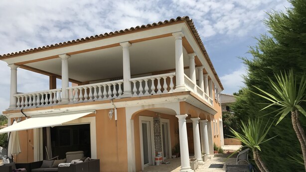 A two-story house with a balcony, stone flooring, and outdoor furniture. - Location Villa (Fréjus)