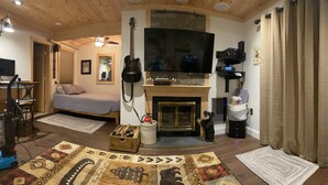 Een gezellige woonkamer met een open haard, een televisie en een gitaar.