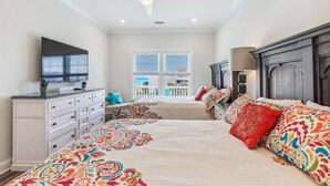 A bedroom with a large bed, a dresser, a TV, and a ceiling fan. - Shore Beats Work 6BR 5BA Beach Home with Outdoor Pool, Hot tub, and Game Room (North Myrtle Beach)