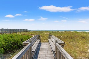 A wooden boardwalk leading to a beach with a clear sky. - Cassie - Pet Friendly, Oceanfront home in Cherry Grove (North Myrtle Beach)