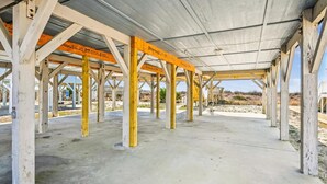 An open pavilion with a concrete floor and wooden beams, surrounded by a natural landscape. - Chase - Pet Friendly Oceanfront House in Cherry Grove (North Myrtle Beach)