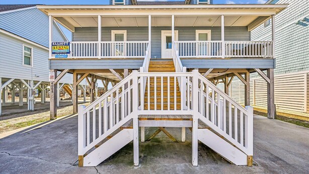 A two-story house with a covered front porch and a staircase leading to the upper level. - Chase - Pet Friendly Oceanfront House in Cherry Grove (North Myrtle Beach)