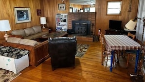A cozy living room with a fireplace, a sofa, a coffee table, and a dining table with chairs. - Eagle Landing, Views, WI-FI, Private, Spacious! (Boone)