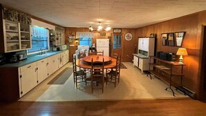 A compact kitchen with a central island, wooden cabinets, and a dining area with a round table. - Eagle Landing, Views, WI-FI, Private, Spacious! (Boone)