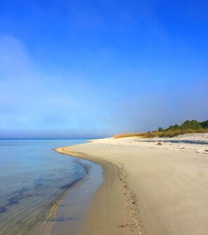 A beach with clear water, sandy shore, and greenery in the background. - Fall specials are here! Htd pool, 4 min to bch, SUP, golf cart, scrn porch, deck (Port St. Joe)