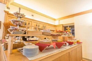 Ein reichhaltiges Buffet mit verschiedenen Speisen und Getränken, einer Holztresen und einem dekorativen Anhänger.
