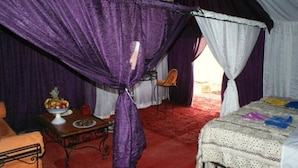 A room with a bed, a table with a fruit bowl, and a chair. - Tizi Plus Desert (Zagora)