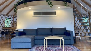 A cozy living area with a sectional sofa, a small round table, and a patterned rug. - Relax and unwind at Solar Solitude (Mathias)