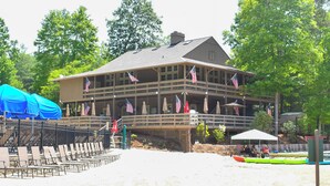 A wooden building with multiple balconies, American flags, and outdoor seating. - Petit Crest Villas (Jasper)