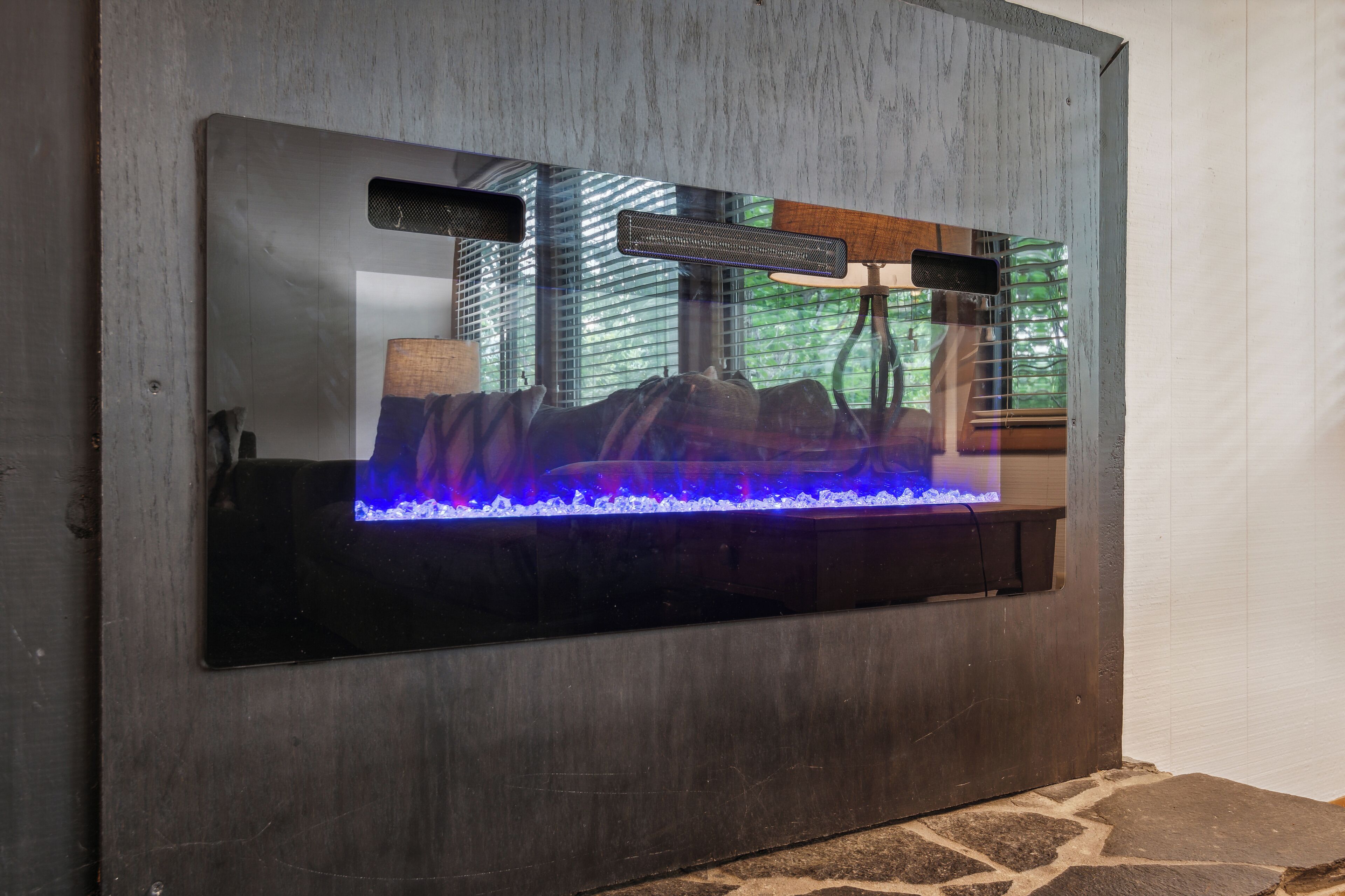 A modern fireplace with a built-in TV screen displaying a nature scene.
