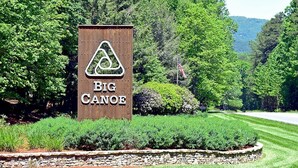 A wooden sign with the text "BIG CANOE" and a triangular logo. - Petit Crest Villas (Jasper)