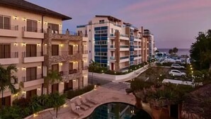 A multi-story hotel with balconies, a swimming pool, and a view of the ocean. - Playa Laguna Beach Condos (Cabarete)