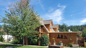 Eine Lodge mit Holzfassade, einem Balkon und einem Schild mit der Aufschrift 'By the Way Suites'.