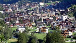 A mountainous town with traditional wooden buildings, a church, and a clear view of the surrounding forest. - Alpha Hotel (Saas Grund)