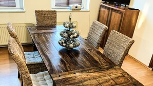Een eethoek met een houten tafel, rieten stoelen en een decoratief middelpunt.