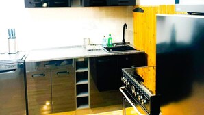 Een moderne keuken met roestvrijstalen apparatuur, een houten aanrechtblad en een inbouwoven.