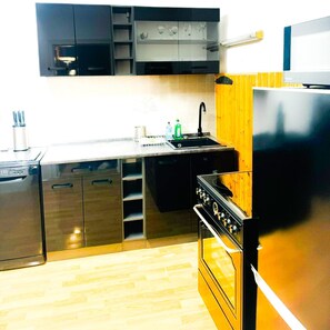 Una cocina moderna con electrodomésticos de acero inoxidable, encimera de madera y horno empotrado.