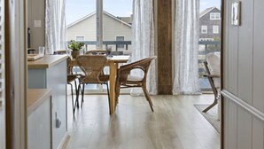 Une cuisine moderne avec un coin repas, de grandes fenêtres et une vue sur le quartier.