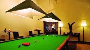 A pool table with balls, a lamp, and a decorative item on the wall. - Bumi Hills Safari Lodge (Bumi Hills)