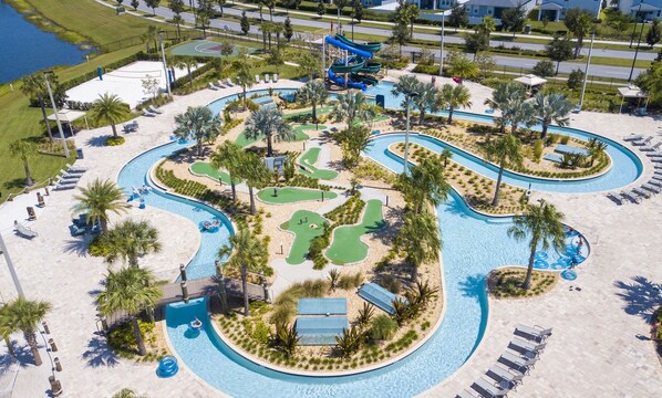 Relax by the winding pool or tee off on the nearby golf course, surrounded by lush greenery and palm trees.