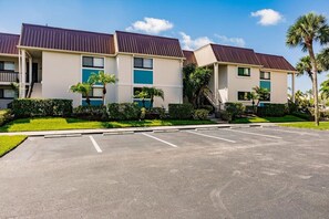 Ein mehrstöckiges Hotel mit Parkplatz davor.