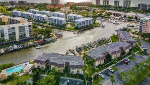 Zona costera urbana con edificios residenciales, un puerto deportivo y una gran extensión de agua.