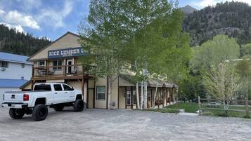 Un bâtiment à deux étages, sur lequel on peut lire l’inscription « Rice Lumber Co. », et un camionnette blanche garée devant.