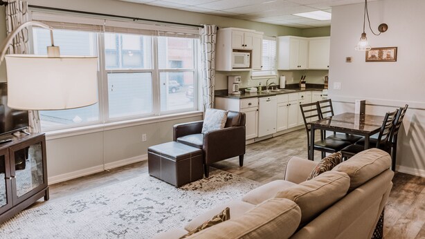 A spacious living room with a sofa, a coffee table, and a dining area with a table and chairs. - Bay Breeze across from Waterfront (Eureka)