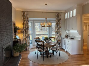 A dining area with a round table, chairs, and a chandelier. There is a kitchen area with cabinets and a countertop. - SOUTHERN LIVING! Newly renovated! Private with Mountain views-sleeps 16 (Kingston)