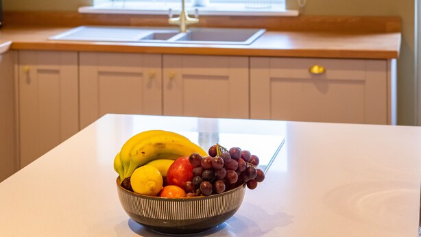A kitchen with a white countertop, a bowl of fruit, and pendant lights. - The Patches (Shrewsbury)