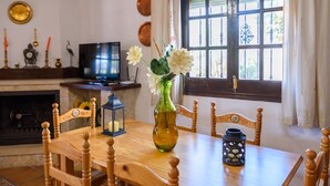 A wooden dining table with chairs, a vase with flowers, a candle, and a lantern. - Villa Turistica Almuñécar by Ruralidays (Granada)
