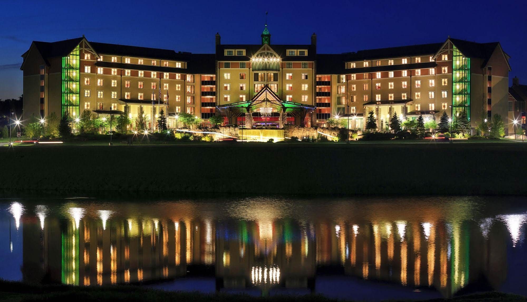 A large, multi-story hotel with a central courtyard and a reflective pool.