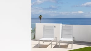 A balcony with two white lounge chairs facing a view of the ocean. - Remote workers paradise @ the Atlantic  (Las Caletillas)