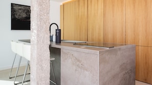 A modern kitchen with a marble countertop, wooden cabinets, and a black kettle. - Remote workers paradise @ the Atlantic  (Las Caletillas)