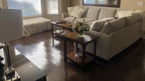 Una sala de estar con sofá, mesa de centro y lámpara.