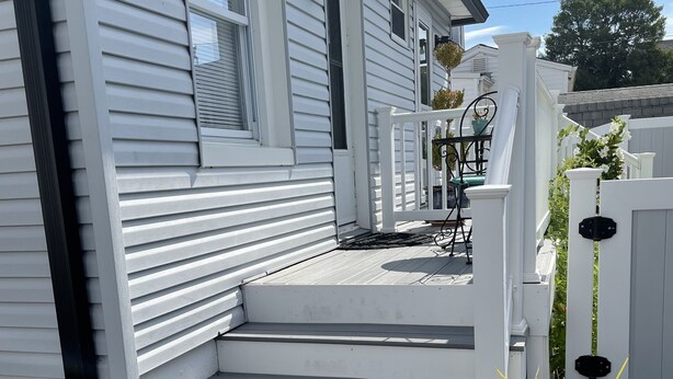 A white house with a front porch and steps leading to the entrance. - Bradley Beach Quaint Getaway (Bradley Beach)