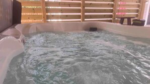 A hot tub with water, wooden walls, and a table. - Oatland Island Family Cottage 10 minutes from Tybee Island and Historic Savannah (Savannah)