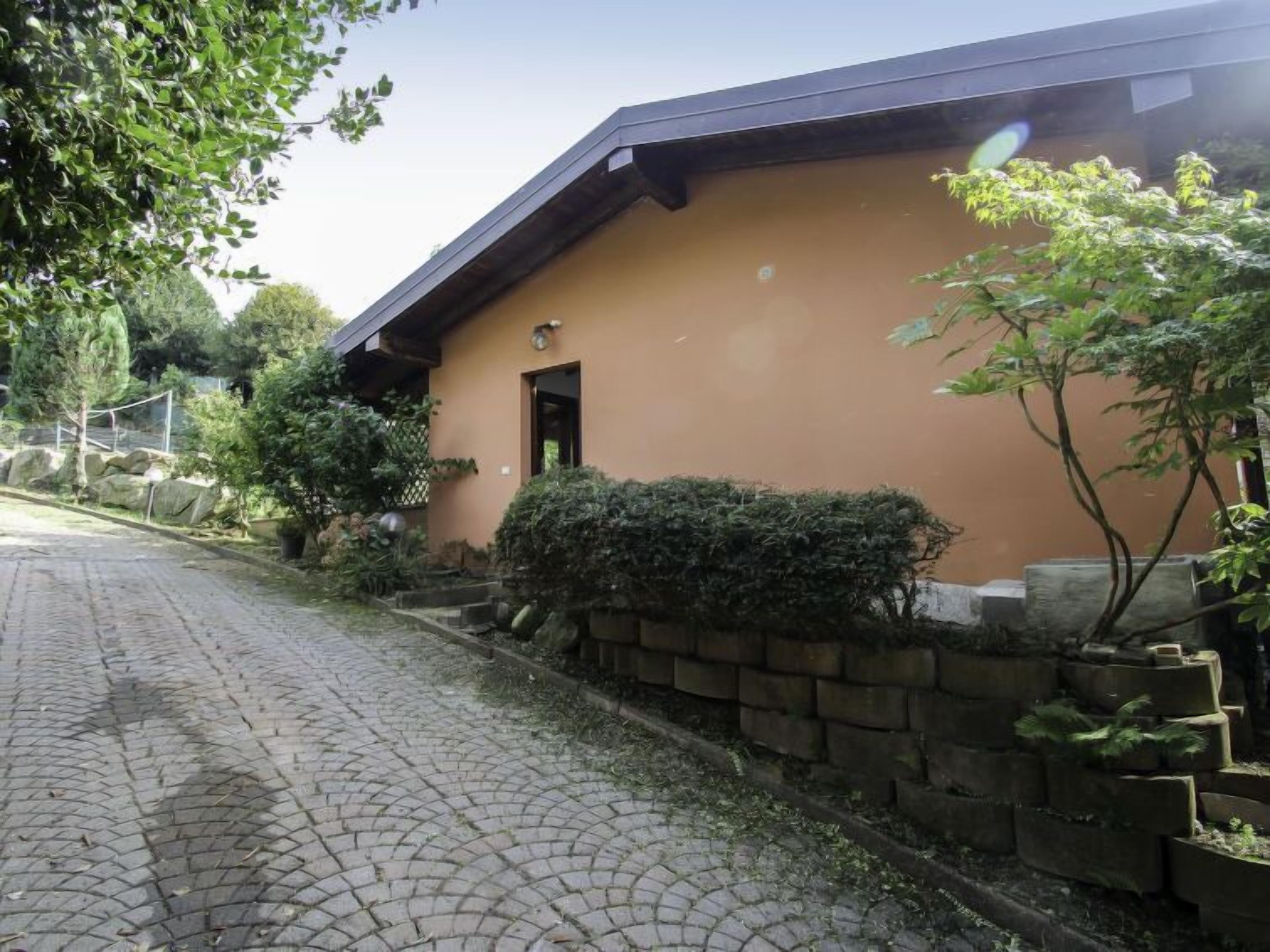 A building with a paved driveway and stone steps leading to a door.