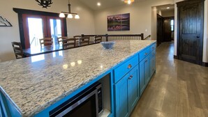 A kitchen with granite countertops, blue cabinets, and pendant lighting. - Beautiful Family Getaway with Breathtaking Teton Views (Tetonia)