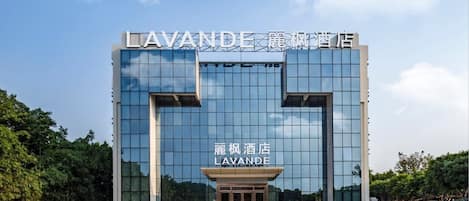 Un moderno edificio de hotel con un letrero llamativo que dice "LAVANDE" y caracteres chinos encima.