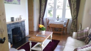 Un salon confortable avec une cheminée, une table à manger avec des chaises et un canapé.