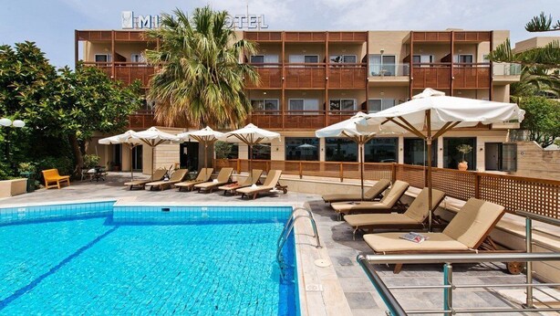A hotel with a swimming pool, sun loungers, and umbrellas. - Minos All Suites (Rethymno)