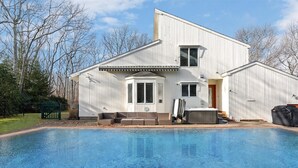 Une maison à deux étages avec une piscine à l’avant.