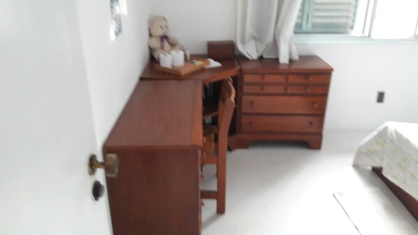 A bedroom with a wooden dresser, a chair, and a bed. - Cozy Demi Suite In Friendly House (São Paulo)