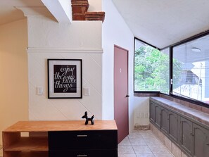 A kitchen with a wooden countertop, a black cabinet, a framed quote on the wall, and a window with a view of greenery. - Spacious 8-bedroom House in Central Guadalajara (Guadalajara)